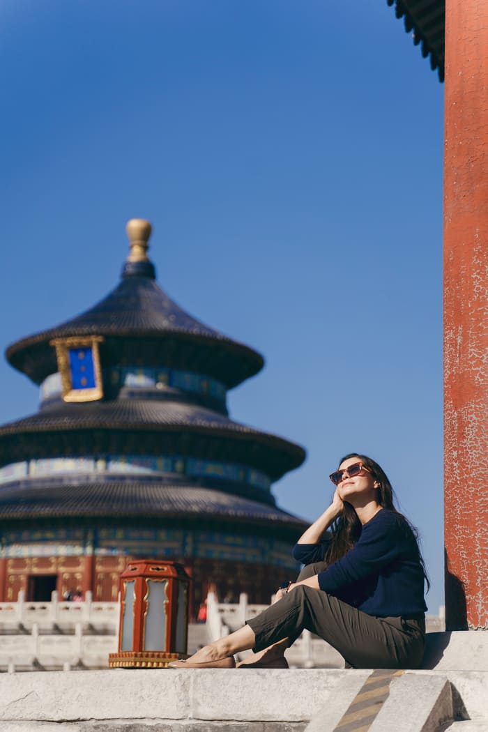 Mujer frente a un edificio chino disfrutando el panorama